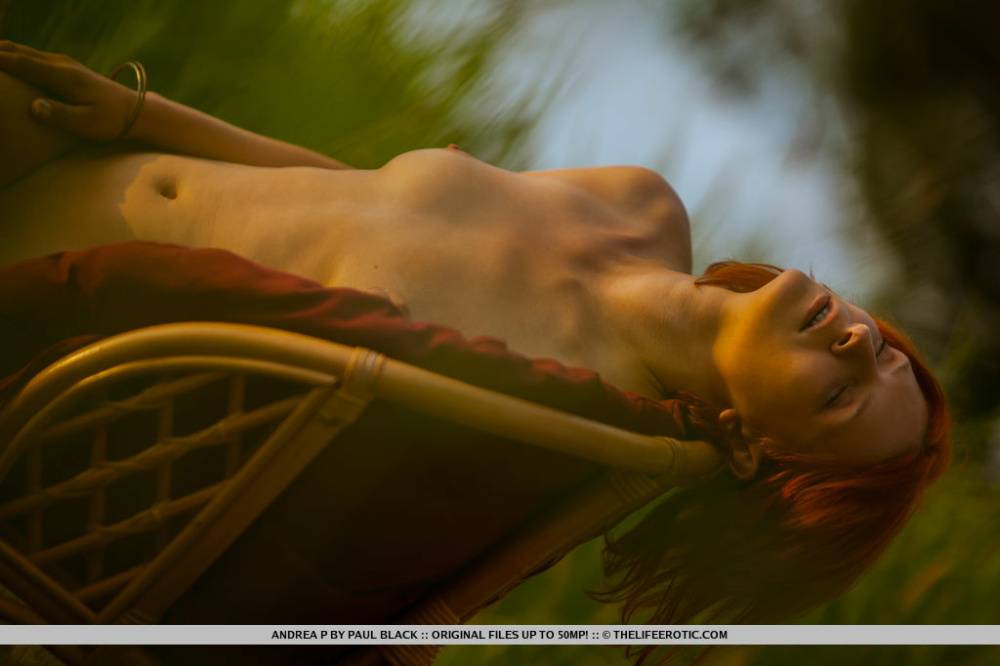Natural redhead Andrea P models totally naked on a chair near the water - #2
