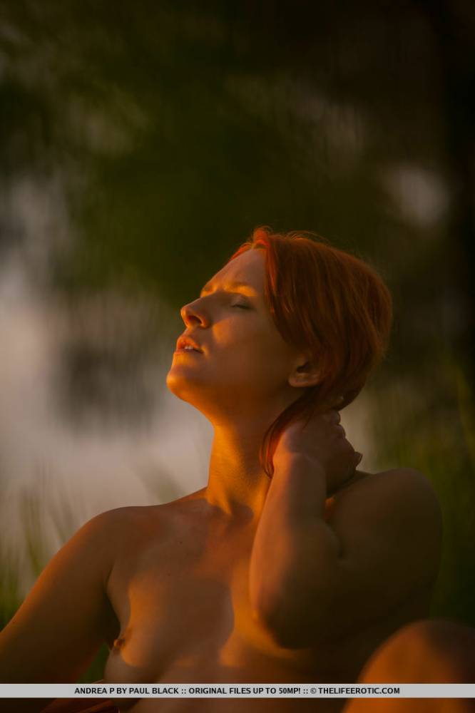 Natural redhead Andrea P models totally naked on a chair near the water - #13