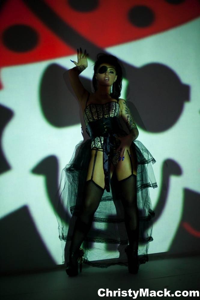 Solo girl Christy Mack wears an eye patch and lingerie while posing in shadows - #10