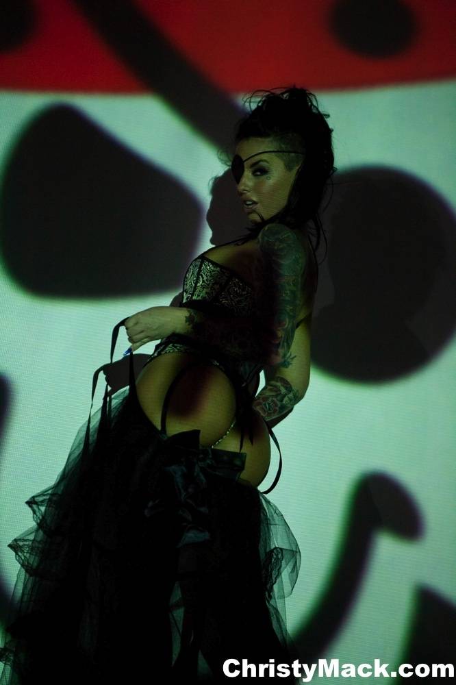 Solo girl Christy Mack wears an eye patch and lingerie while posing in shadows - #1