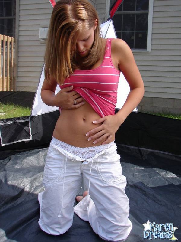 Young redhead Karen slips white pants over her thong clad ass in the backyard - #1