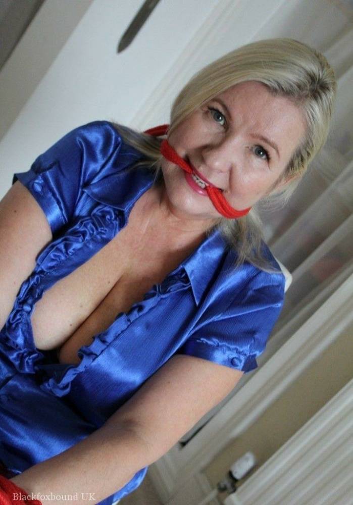 Older blonde is gagged and tied up in a variety of outfits inside her house - #8
