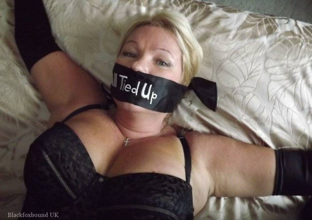 Busty older blonde is left tied up and gagged in numerous outfits - #5