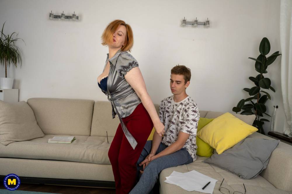 Redheaded cougar seduces and fucks a young lad on a sofa - #7