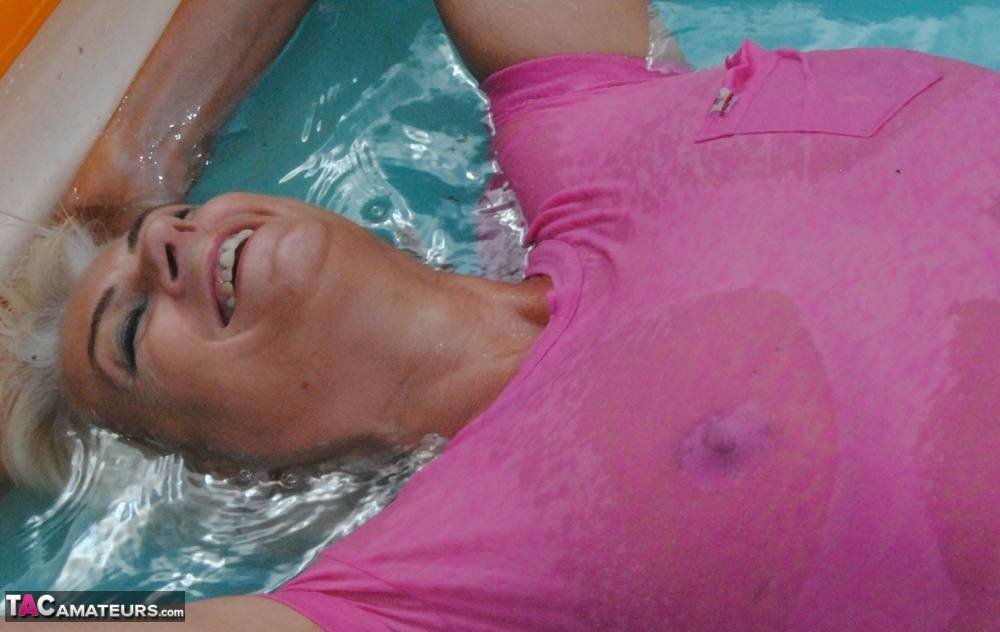 Mature blonde Dimonty takes off her wet T-shirt while in a wading pool - #16