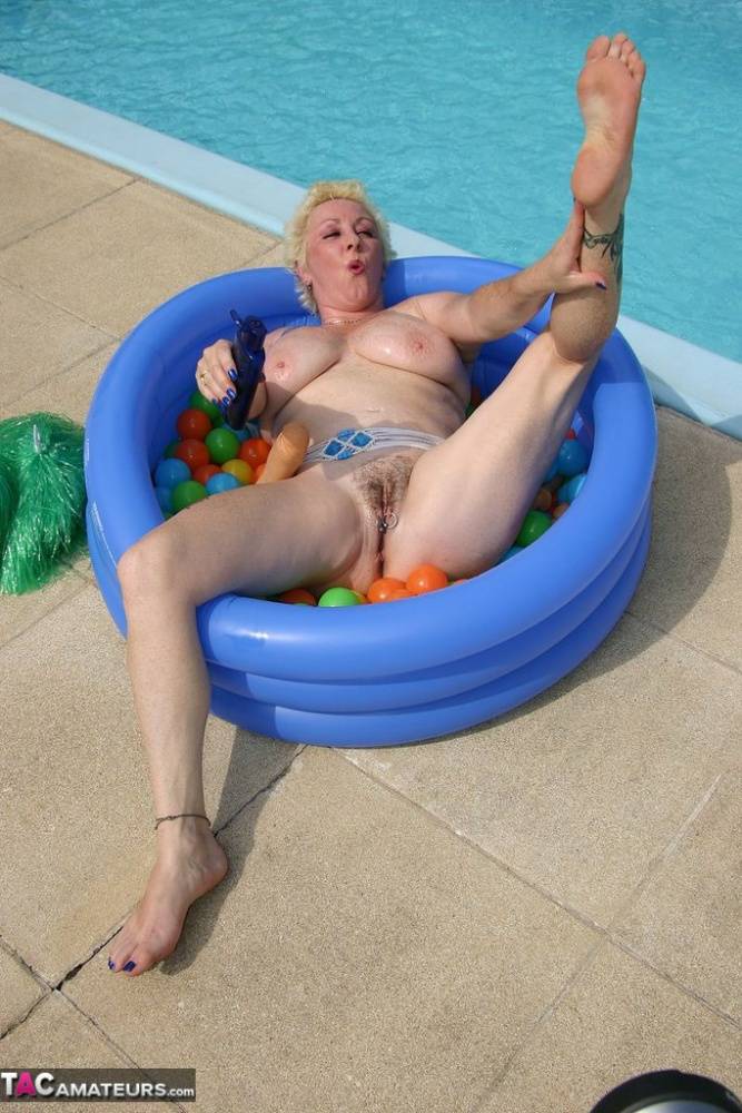 Mature blonde Mary Bitch dildos her snatch in a wading pool by a swimming pool - #14