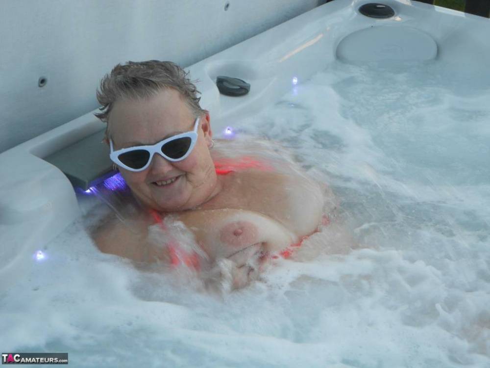 Fat nan bares her boobs while in a patio hot tub before getting naked on a bed - #12