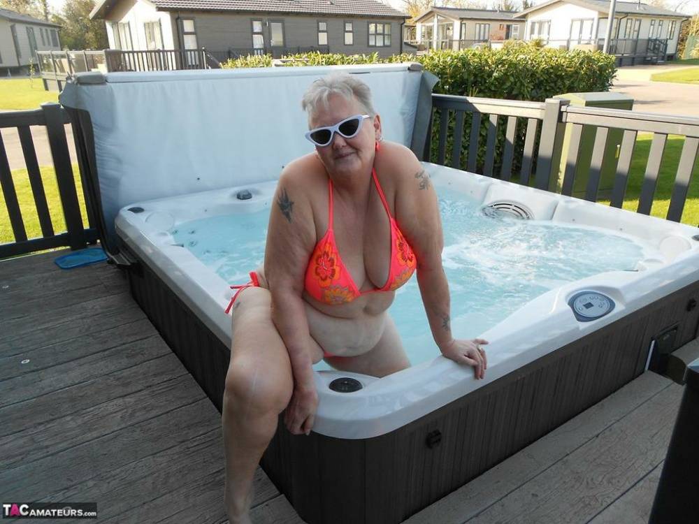 Fat nan bares her boobs while in a patio hot tub before getting naked on a bed - #11