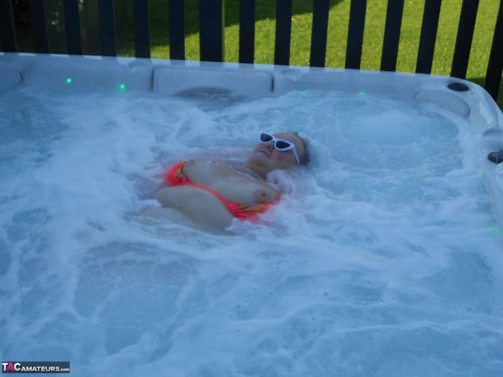 Fat nan bares her boobs while in a patio hot tub before getting naked on a bed - #4