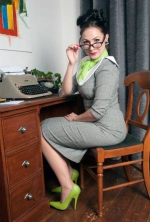 MILF secretary Sophie Delane in glasses stripping to spread naked at her desk on amateurlikes.com