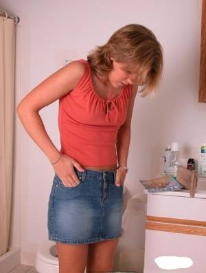 Amateur girl Karen hikes her denim skirt in the bathroom to expose her panties on amateurlikes.com