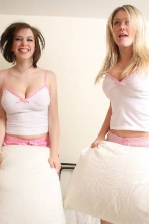 Young blonde Brooke Little and a girlfriend expose their big naturals on a bed on amateurlikes.com