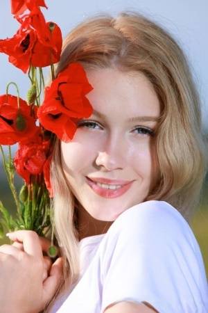 Sweet teen Genevieve Gandi strips naked in a field of blooming flowers on amateurlikes.com