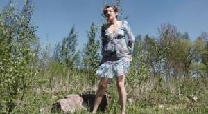 Clothed woman Sasha S hitches up her dress to take a pee on a rock on amateurlikes.com