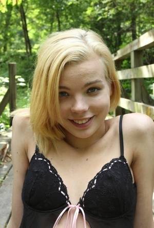 Cute teen amateur Sophia Kitten posing in nude in knee high socks in woods on amateurlikes.com