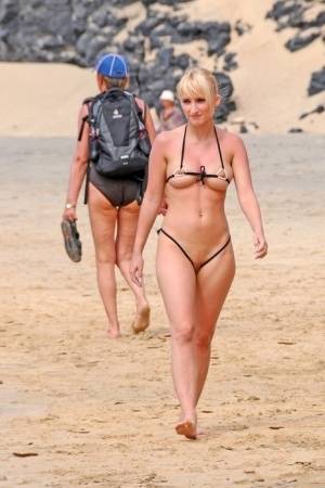 Hot blonde removes a skimpy bikini during a visit to a public beach on amateurlikes.com