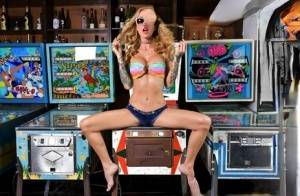 Inked chick Sarah Jessie toys her pussy atop a pinball machine while alone on amateurlikes.com