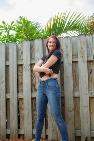Hot redhead Andy Adams loses her t-shirt & jeans in the yard to pose naked on amateurlikes.com